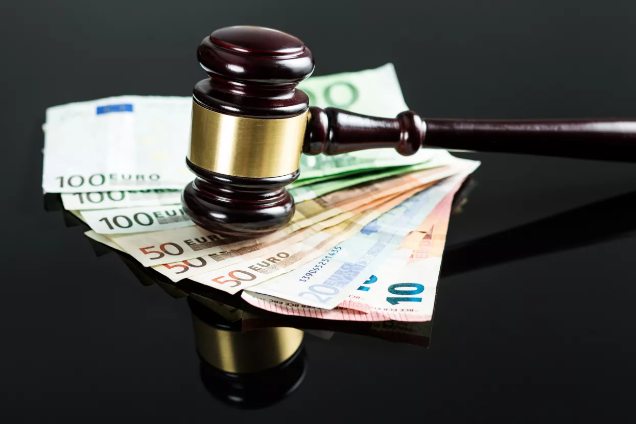 Gavel and euro money on black table.