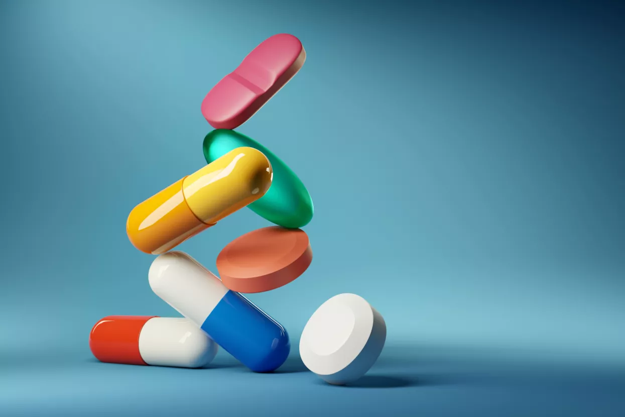 Medical balancing act. A group of medicine pills and antibiotics balacning on top of each other. 3D render illustration.<br>lijekovi, tablete, kapsule