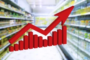 Red growing up large arrow on abstract blur supermarket background. Bar charts and graphs. Rising food prices. Inflation concept. Retail industry. Economy. Stock Market. Grocery Store. Recession. CPI.indeks potrošačkih cijena, CPI, consumer price index, inflacija, rast cijena, cijene, 