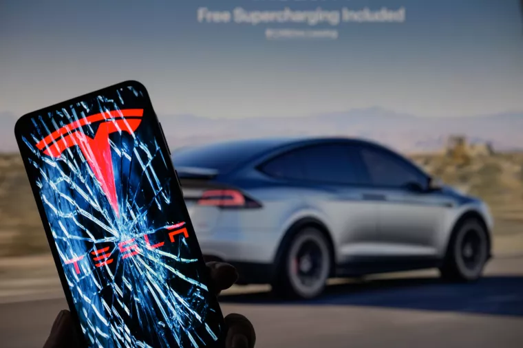 Tesla logo is displayed on a mobile phone with Tesla website in the background, seen in this photo illustration. Taken in Brussels, Belgium, On 9 February 2025. JRdes