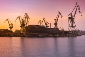 shipyard with large ship under construction at the sunset