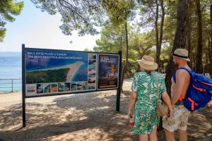 Tourist couple at the Zlatni Rat Golden cape beach on the Adriatic island of Brac in Croatia on 24 August 2025
