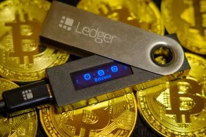 Moscow, Russia - September 8, 2017Cold crypto wallet Ledger Nano S lying on golden bitcoin coins