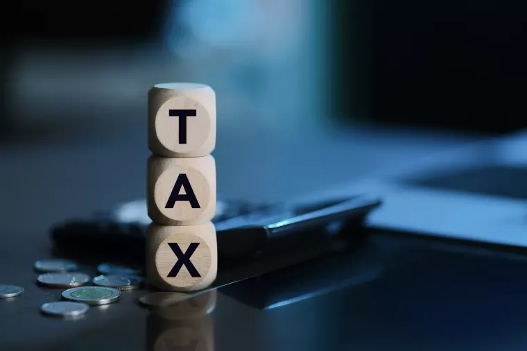 Tax Concept. Wooden Blocks with Calculator and Coins with the Word Tax. Personal Income Tax, Corporate Tax, Financial Research, Documents, Reports and Calculations Concept.